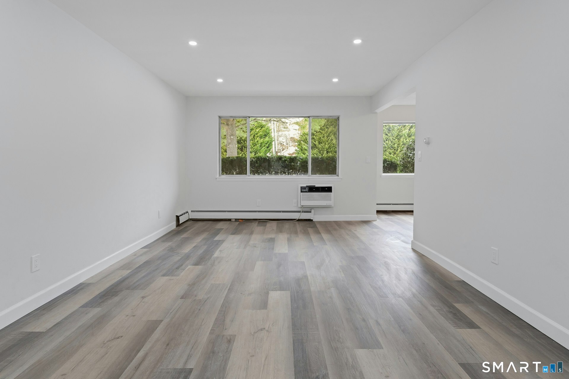 154 Cold Spring Road, Unit 18 Stamford, CT 06905 - Photo 6 of 28 an empty room with wooden floor and windows