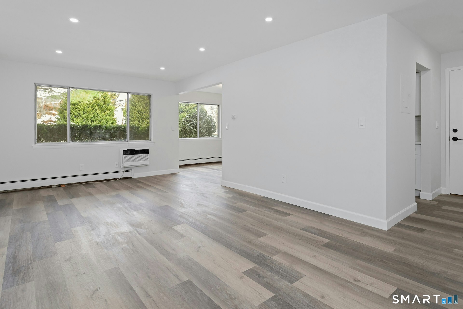 154 Cold Spring Road, Unit 18 Stamford, CT 06905 - Photo 8 of 28 an empty room with wooden floor and windows