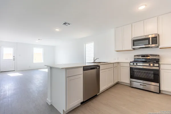 a kitchen with stainless steel appliances granite countertop a stove a sink and a microwave