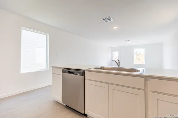 a kitchen with white cabinets and sink