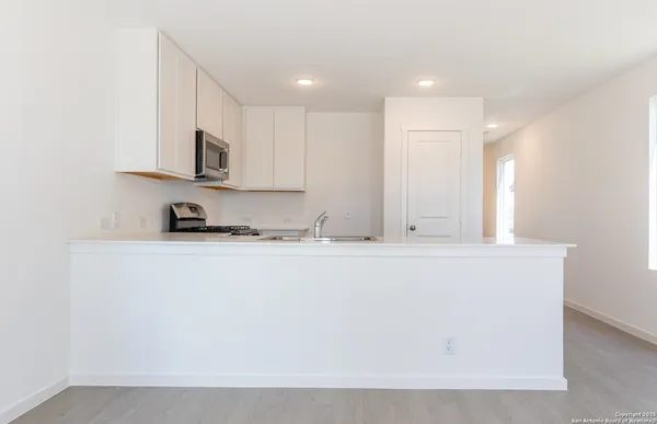 a view of kitchen with stainless steel appliances granite countertop refrigerator sink and stove