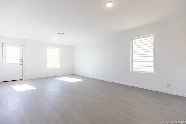 an empty room with windows and closet