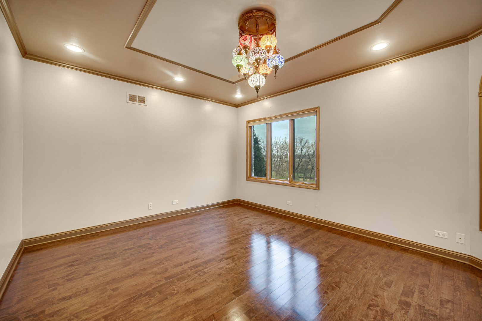 441 Delaware Circle Bolingbrook, IL 60440 - Photo 14 of 69 an empty room with wooden floor chandelier and windows