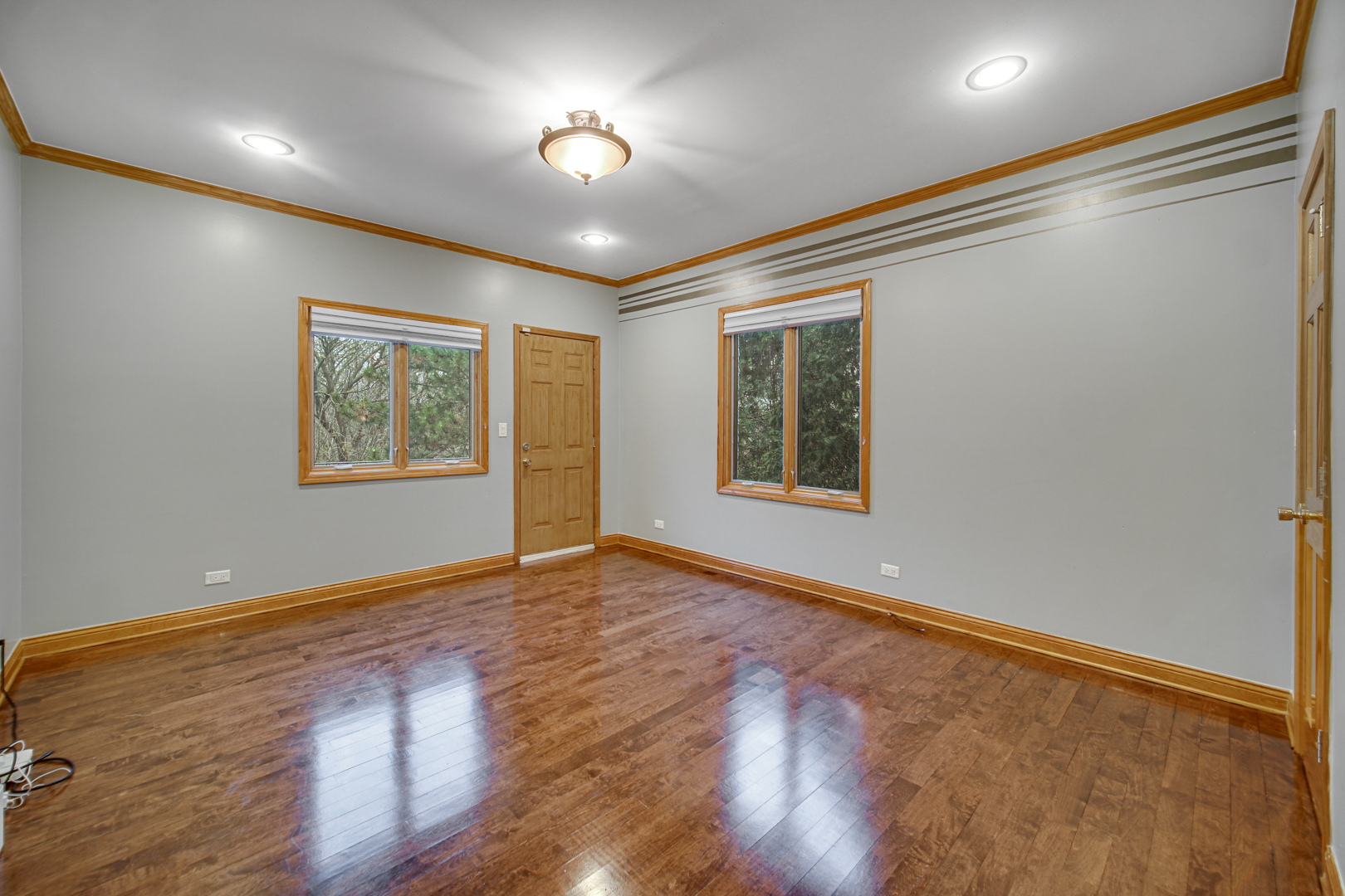 441 Delaware Circle Bolingbrook, IL 60440 - Photo 29 of 69 an empty room with wooden floor chandelier and windows
