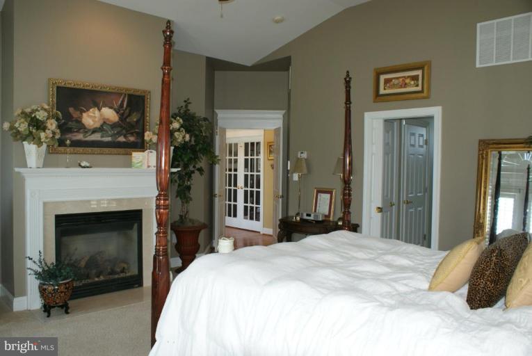 3411 Soper Road Huntingtown, MD 20639 - Photo 26 of 28 a bedroom with a bed and a fireplace