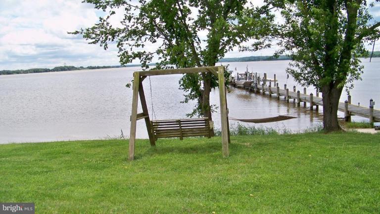 3411 Soper Road Huntingtown, MD 20639 - Photo 10 of 28 a view of a bench in the garden near a lake
