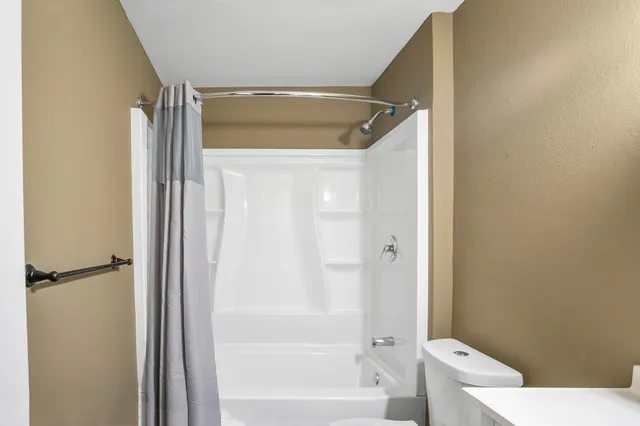 a bathroom with a shower and a toilet