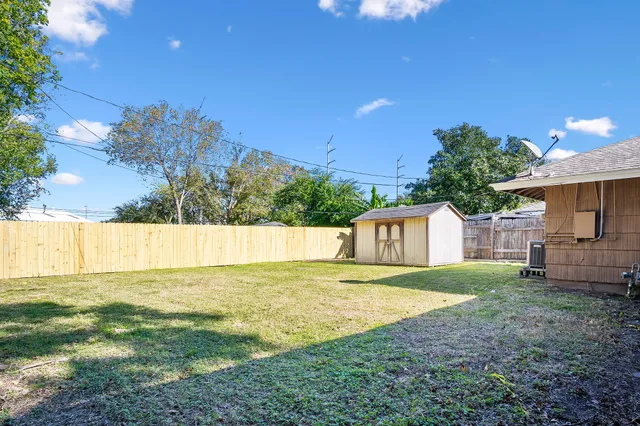 a view of an house with backyard and a tree