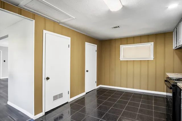 a view of a hallway with closet and a bathroom