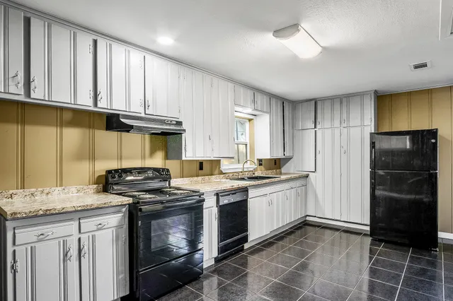 a kitchen with a stove a sink and a refrigerator