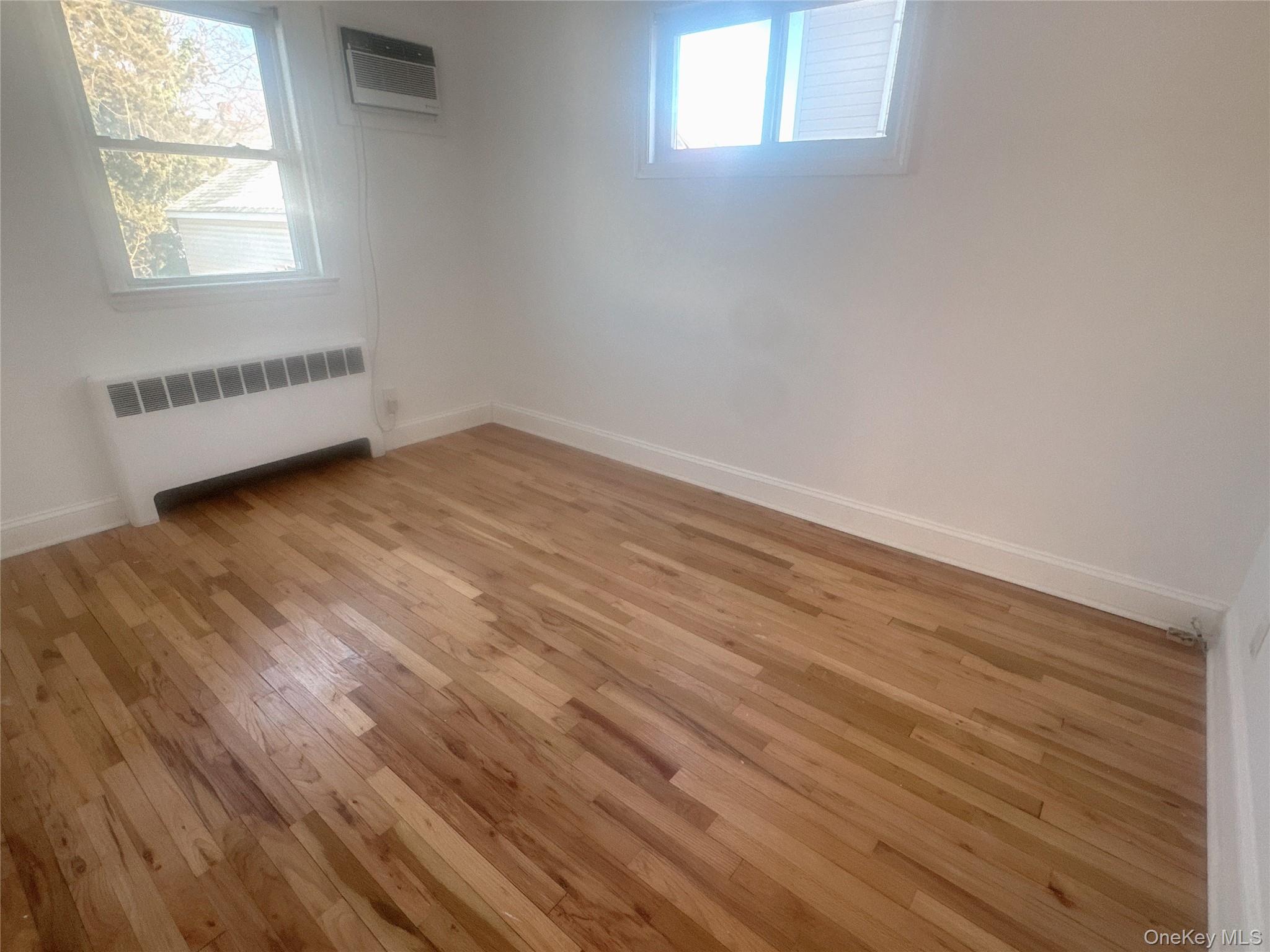 2573 Legion Street Bellmore, NY 11710 - Photo 7 of 13 an empty room with wooden floor and windows