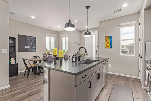 a kitchen with stainless steel appliances granite countertop a stove center island a dining table and chairs