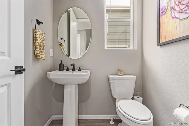 a bathroom with a toilet a sink and a mirror
