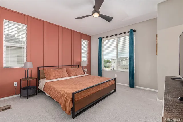 a bed sitting in a spacious bedroom next to a window