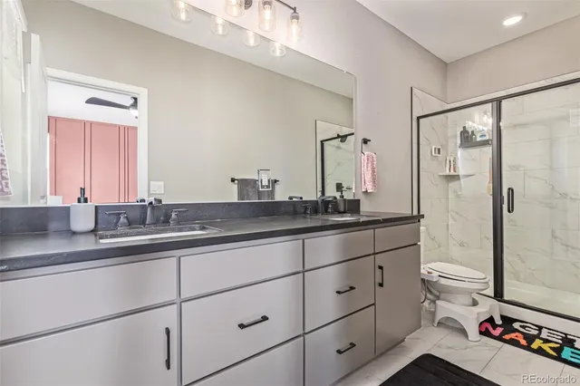 a bathroom with a double vanity sink toilet and shower