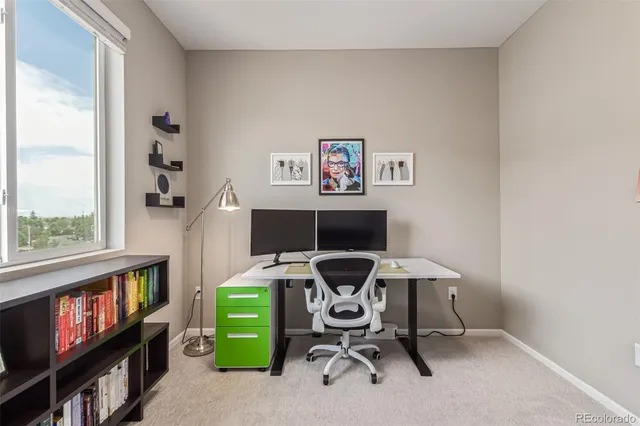 a view of a workspace with furniture and a window