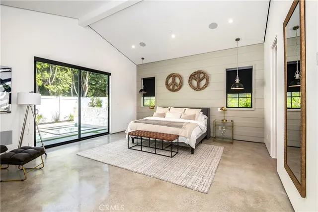 a bedroom with a bed tv and window