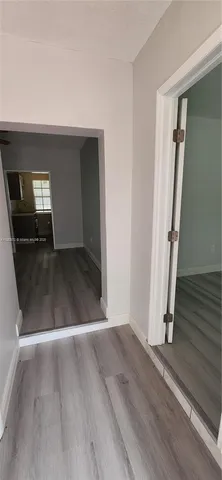 an empty room with wooden floor and stairs