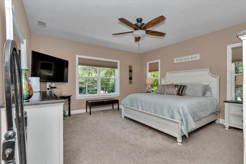 4359 Southwest 117th Place Ocala, FL 34476 - Photo 23 of 58 a spacious bedroom with a bed and a flat screen tv