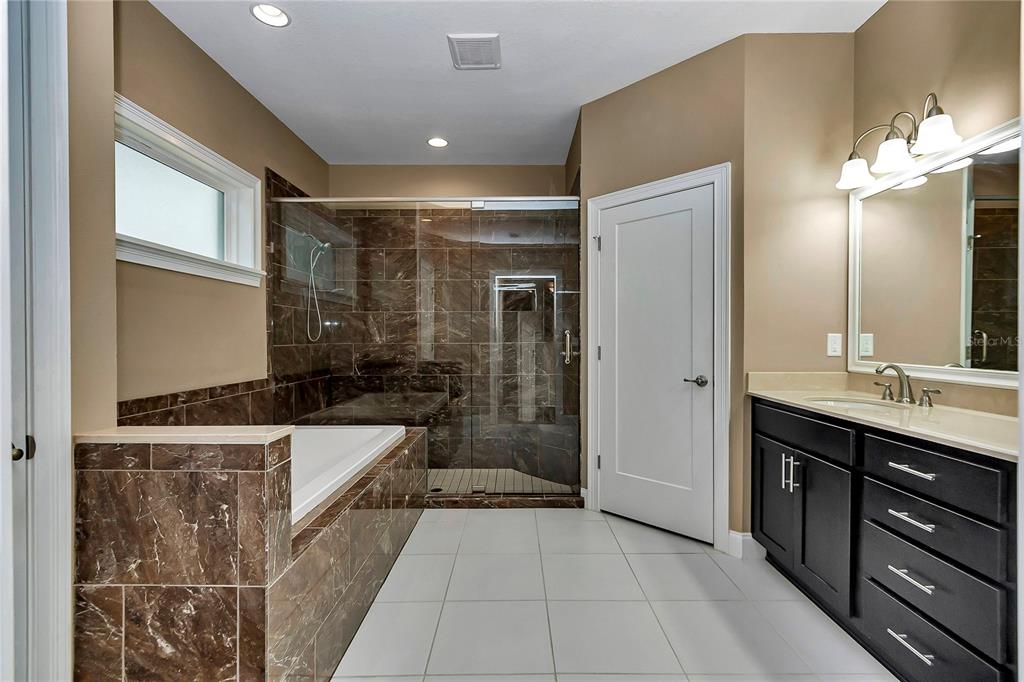 4359 Southwest 117th Place Ocala, FL 34476 - Photo 25 of 58 a bathroom with a bathtub a double vanity sink a vanity and a large mirror