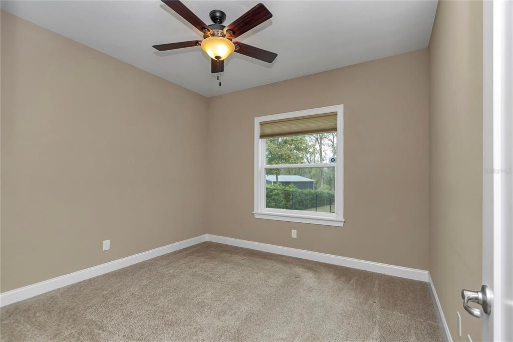 4359 Southwest 117th Place Ocala, FL 34476 - Photo 27 of 58 an empty room with a window and a fan
