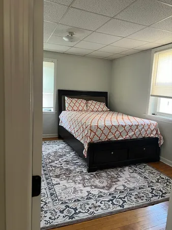 a bed sitting in a bedroom next to a window with a lamp