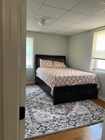 a bed sitting in a bedroom next to a window with a lamp