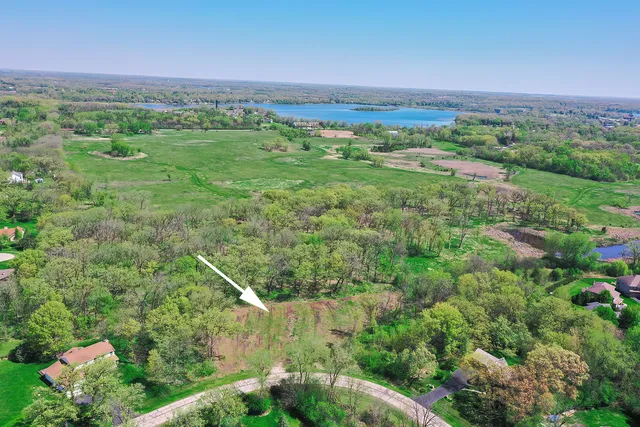 a view of a lush green outdoor space with a swimming pool and valleys in the background