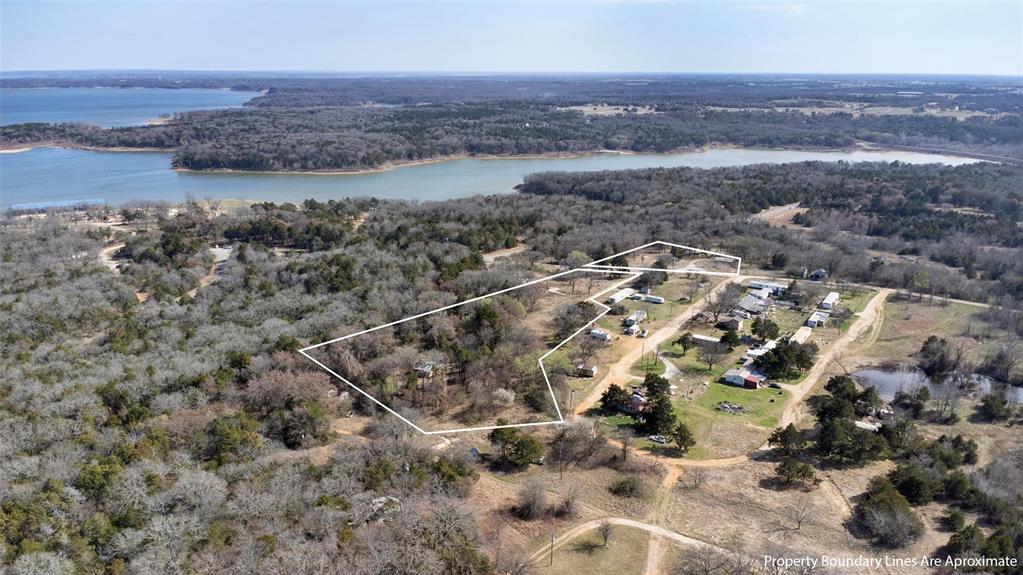 4185 Rock Creek Road Whitesboro, TX 76273 - Photo 2 of 18 Aerial view of property and surrounding area featuring a nearby body of water and property boundaries highlighted