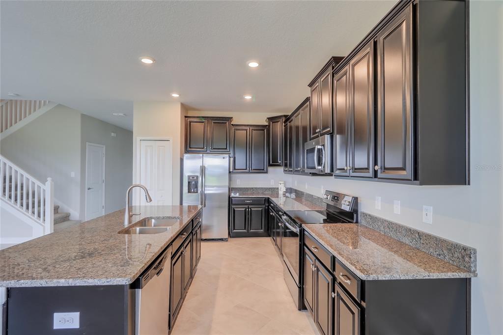 1172 Montgomery Bell Road Wesley Chapel, FL 33543 - Photo 14 of 47 a kitchen with stainless steel appliances granite countertop a sink counter space cabinets and stainless steel appliances