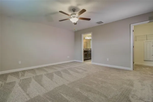 an empty room with closet and ceiling fan