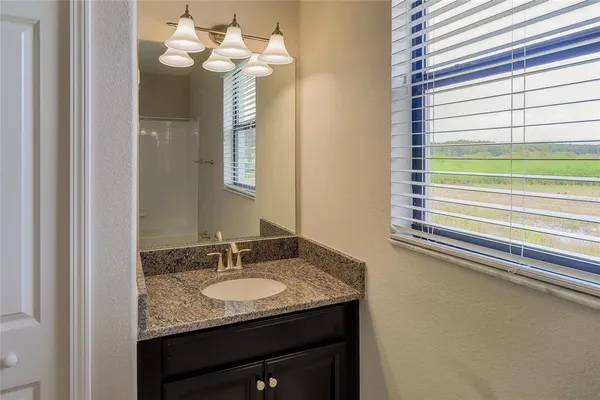 a bathroom with a granite countertop sink and a mirror