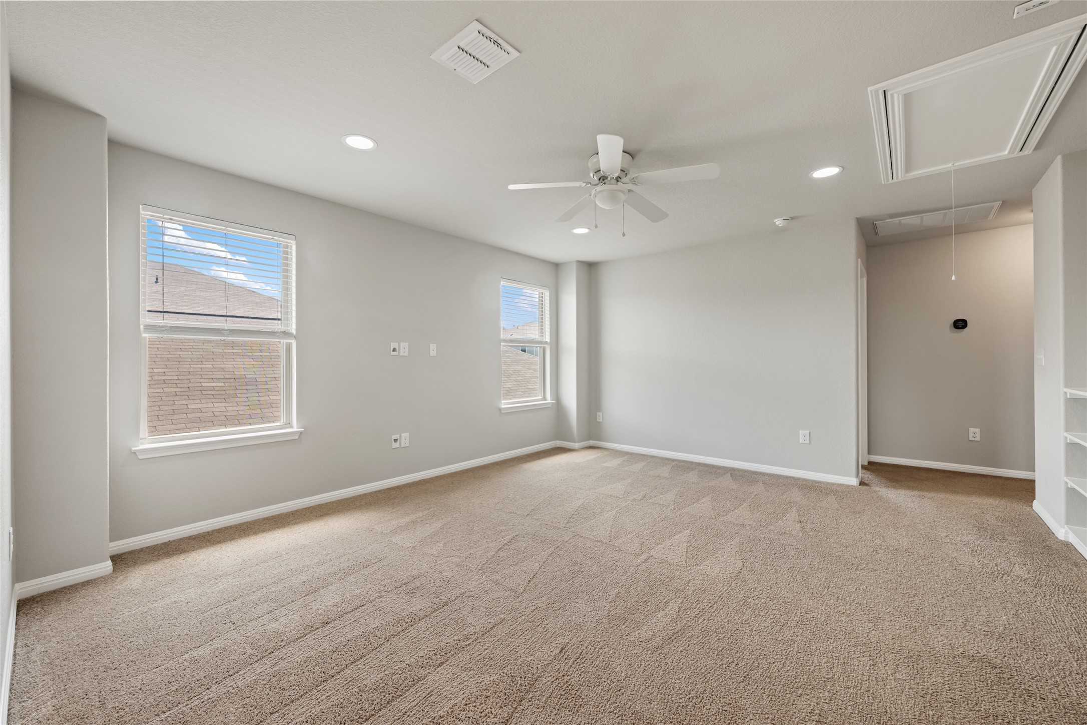 124 Guemal Road Buda, TX 78610 - Photo 24 of 40 A spacious secondary living area features soft carpeting, recessed lighting, and a ceiling fan for optimal comfort.