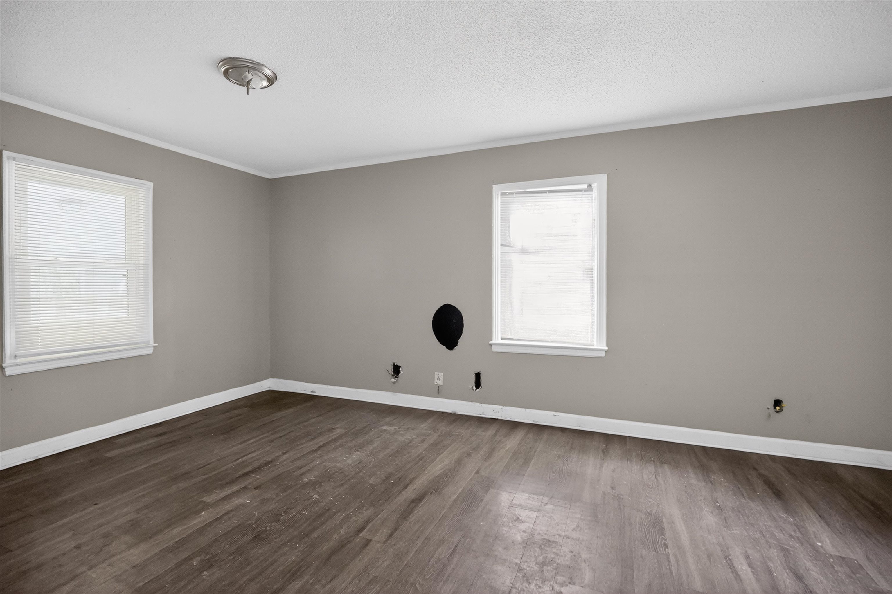 949 Sumter Street Memphis, TN 38122 - Photo 12 of 33 Spacious interior room featuring wood-finish flooring, two windows with blinds, a ceiling-mounted light fixture, and neutral painted walls
