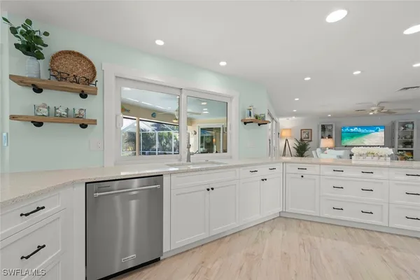 a large white bathroom with a large mirror vanity and a sink