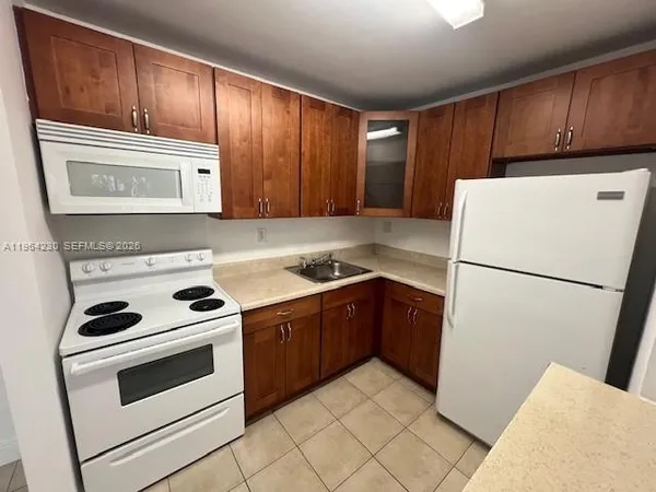 a kitchen with cabinets and white stainless steel appliances