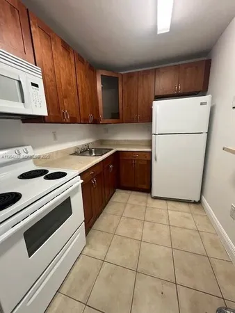 a kitchen with a cabinets and white appliances