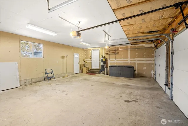 a view of a yard in front of a house with plants and large tree