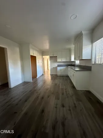 a kitchen with wooden floors and wooden cabinets