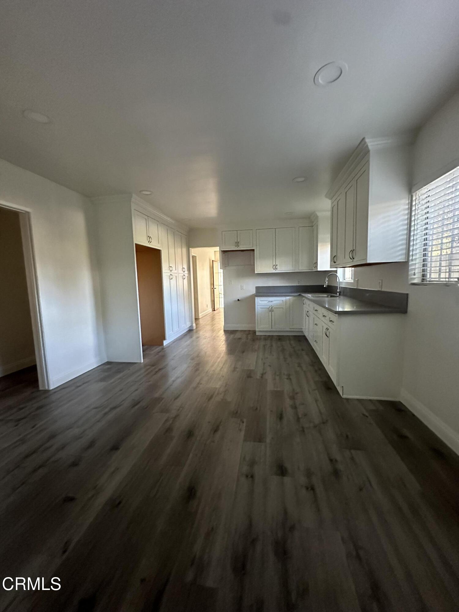 741 New Depot Street Los Angeles, CA 90012 - Photo 12 of 12 a kitchen with wooden floors and wooden cabinets