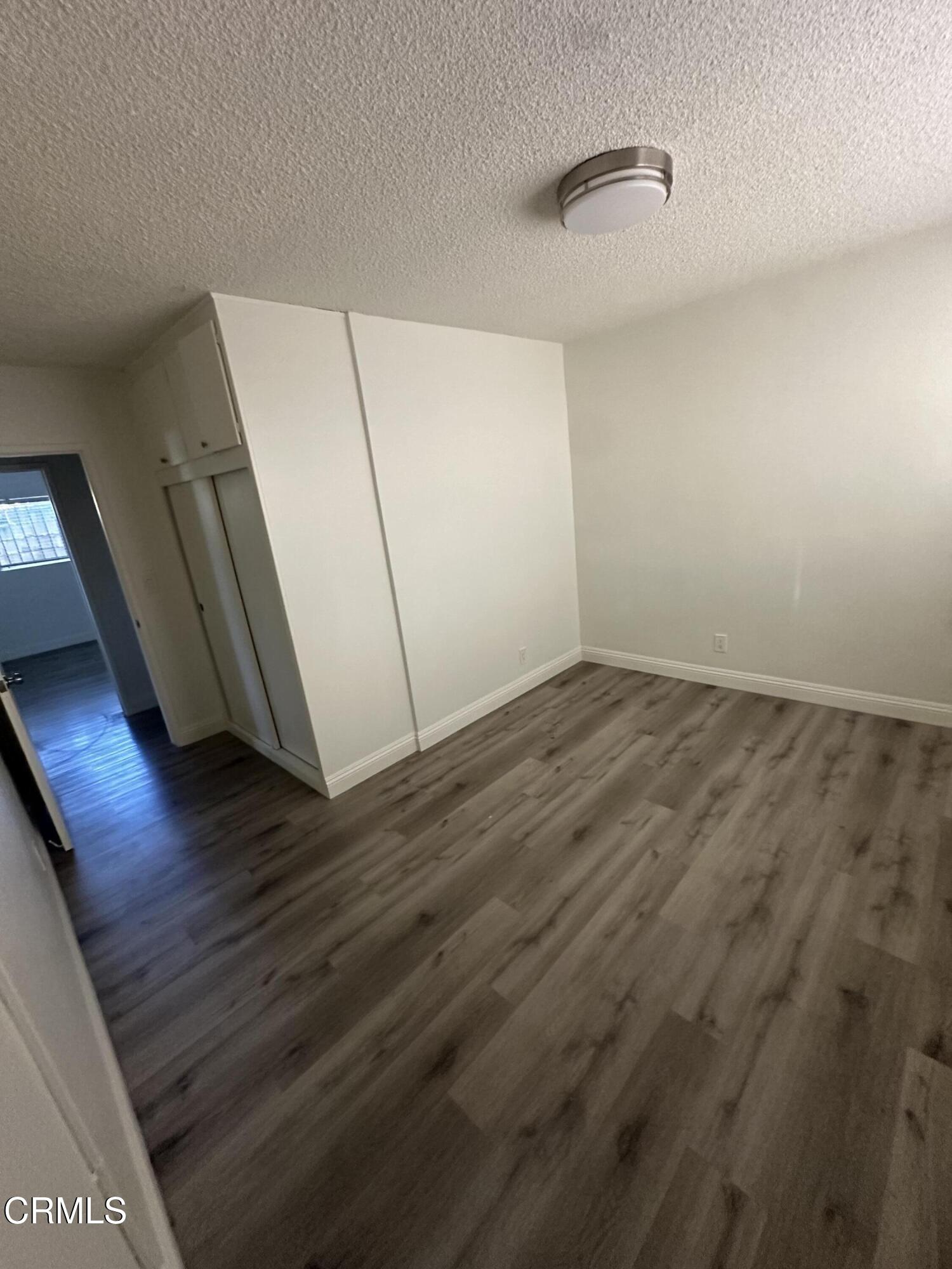 741 New Depot Street Los Angeles, CA 90012 - Photo 3 of 12 a view of an empty room with wooden floor and a window