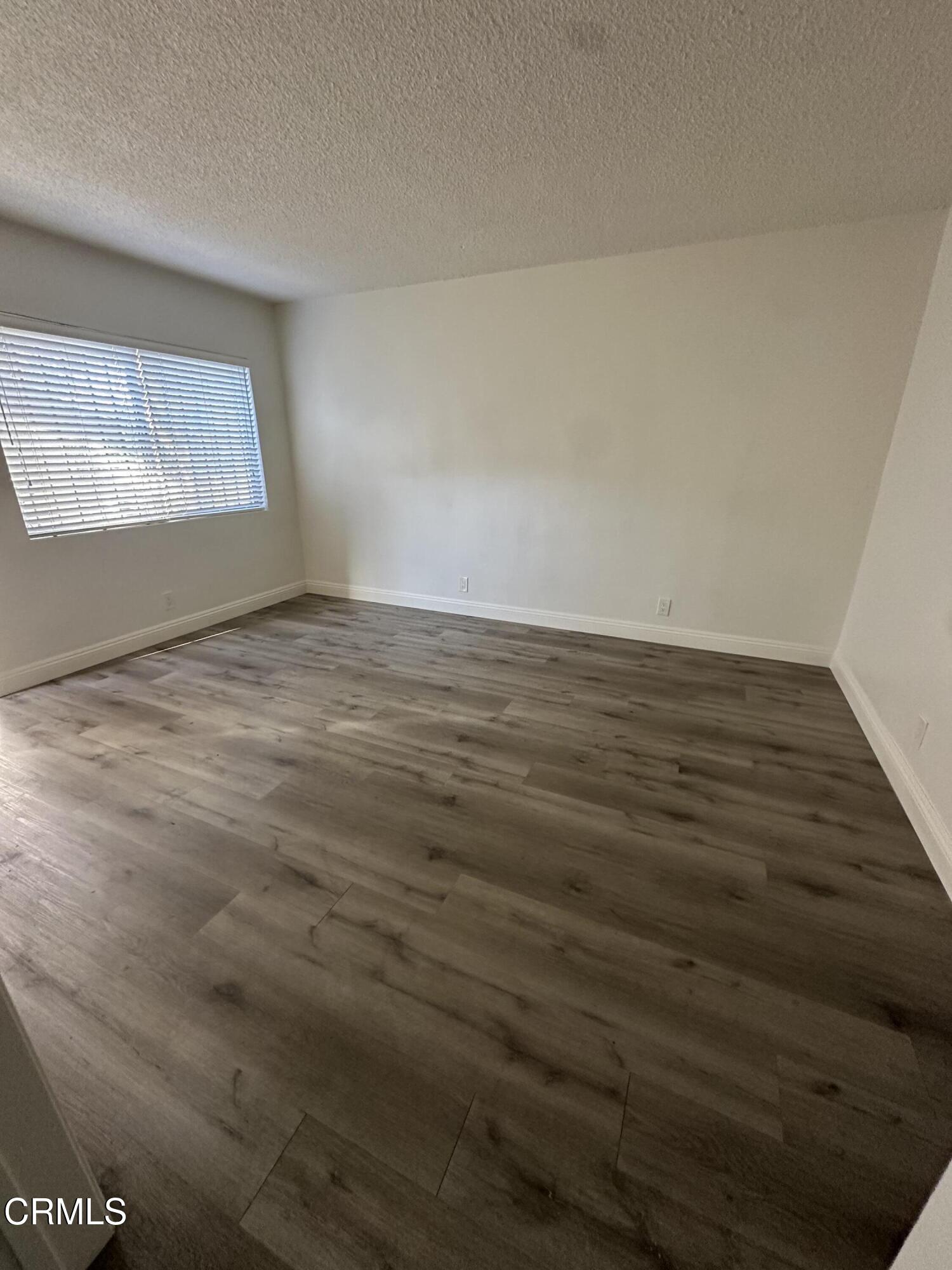 741 New Depot Street Los Angeles, CA 90012 - Photo 8 of 12 an empty room with wooden floor and windows