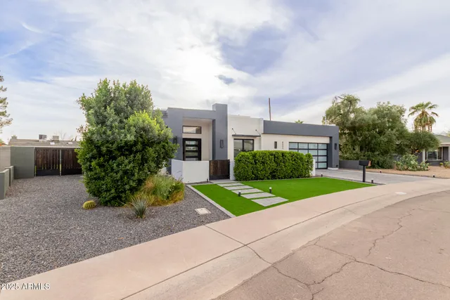 a view of a house with a yard and large tree and plants