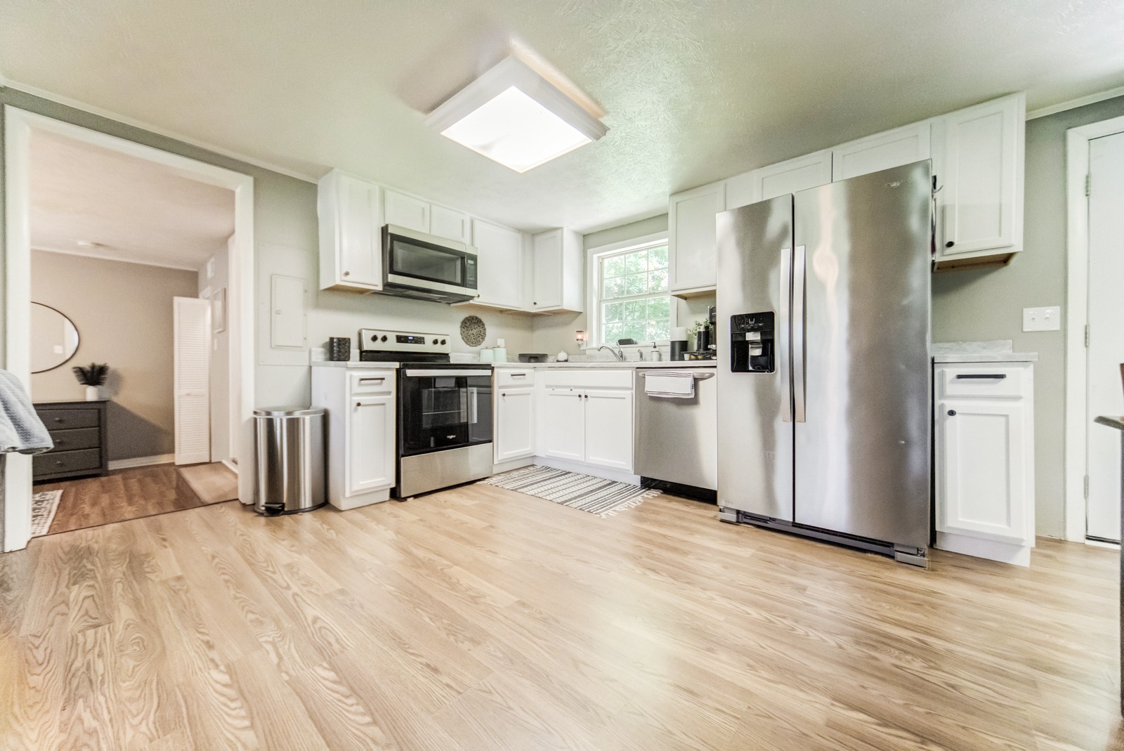 325 Denning Ford Road Portland, TN 37148 - Photo 13 of 35 a kitchen with stainless steel appliances granite countertop a refrigerator oven a sink dishwasher and white cabinets with wooden floor