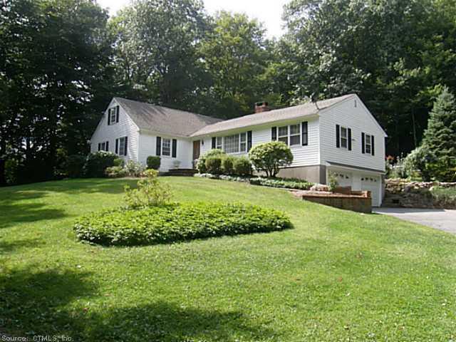 a front view of a house with a garden and trees