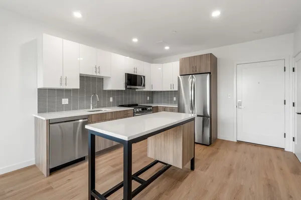 a kitchen with refrigerator cabinets and wooden floor