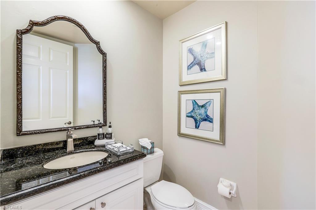 410 Flagship Drive, Unit 903 Naples, FL 34108 - Photo 13 of 29 a bathroom with a granite countertop toilet a sink and mirror