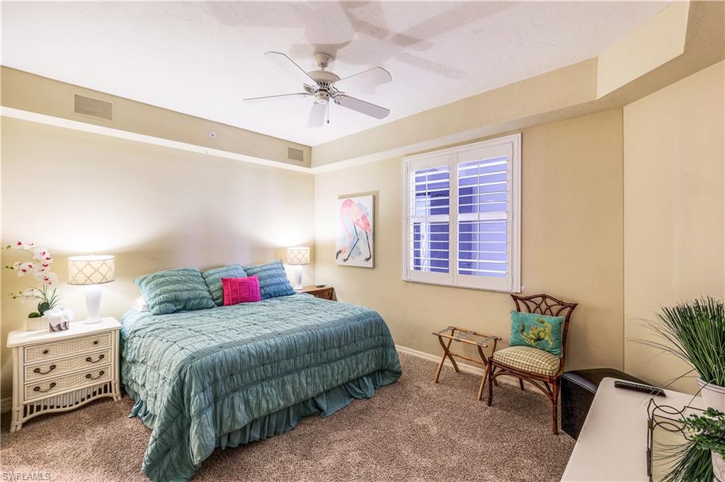 410 Flagship Drive, Unit 903 Naples, FL 34108 - Photo 17 of 29 a bedroom with a bed and a chandelier