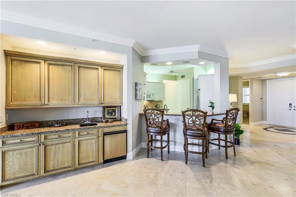 410 Flagship Drive, Unit 903 Naples, FL 34108 - Photo 8 of 29 a kitchen with lots of counter top space and dining table