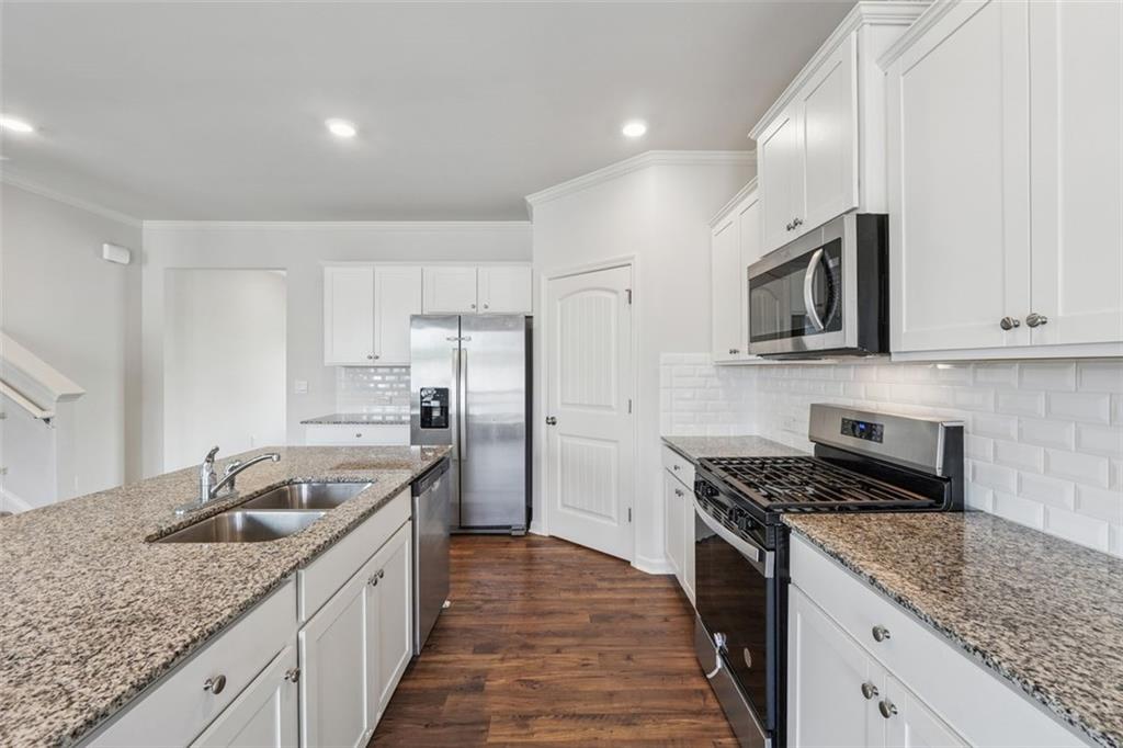 96 Quail Bend Way Dallas, GA 30157 - Photo 9 of 58 a kitchen with stainless steel appliances granite countertop a sink stove microwave and refrigerator